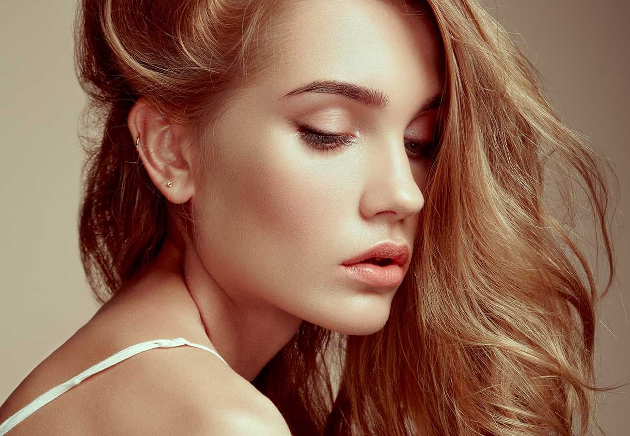 Frau mit langen Haaren schaut leicht nach unten